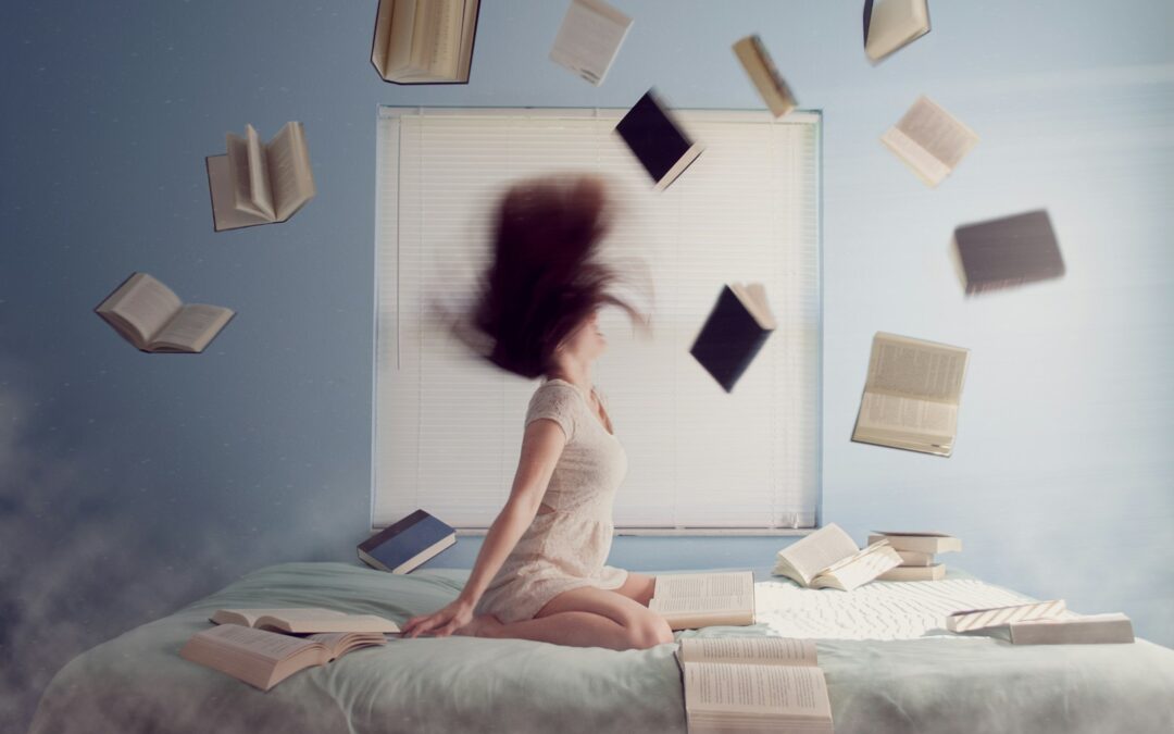 woman sitting on bed with flying books